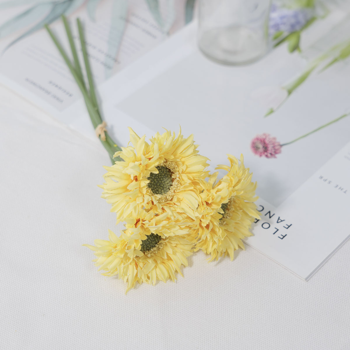 실크플라워 실거베라 조화꽃 27cm 3줄기 번들 옐로우색 테이블에 놓은 사진